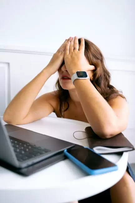 Mujer En Reloj Blanco Y Negro Sentado En Una Silla Frente A La Computadora Portátil