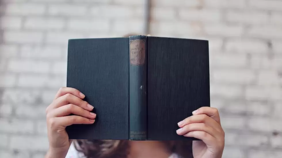 Fotografa De Enfoque Selectivo De Mujer Sosteniendo Libro