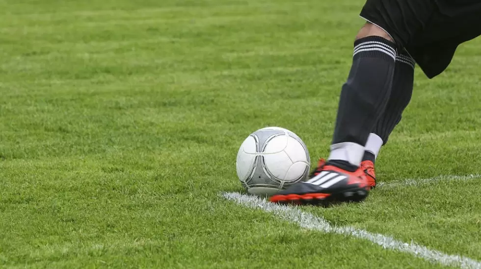 Jugador De Ftbol Pateando Una Pelota De Ftbol Gris Blanca En El Campo De Hierb