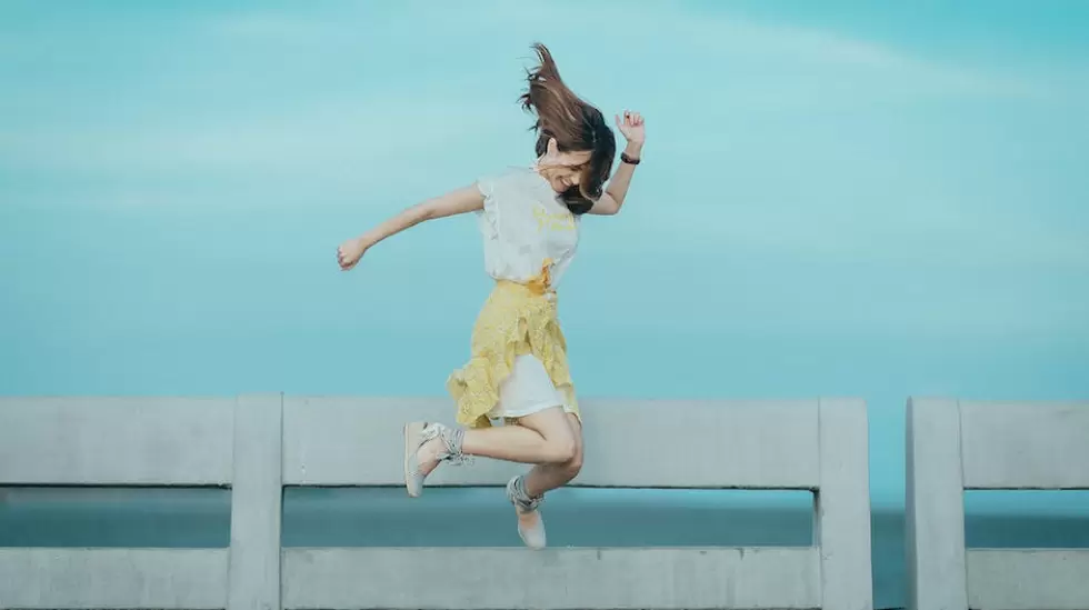 Fotografa De Salto De Mujer Con Vestido Blanco Y Amarillo Cerca Del Cuerpo De A