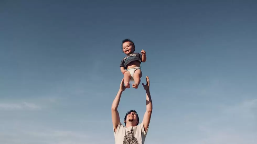 Foto De Un Hombre Criando A Un Beb Bajo Un Cielo Azul, padre