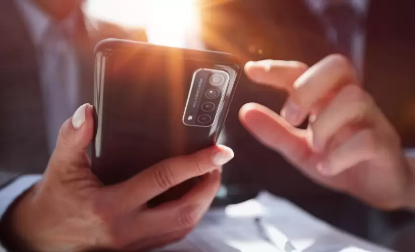 manager-uses-smartphone-while-sitting-table-with-colleague
