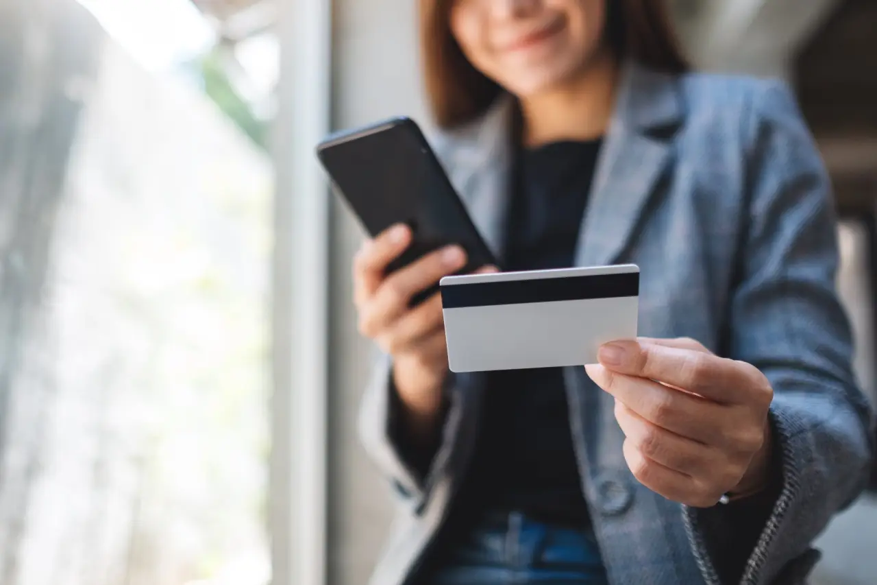 una-hermosa-mujer-asiatica-con-tarjeta-de-credito-para-comprar-y-comprar-en-linea-en-el-telefono-movil