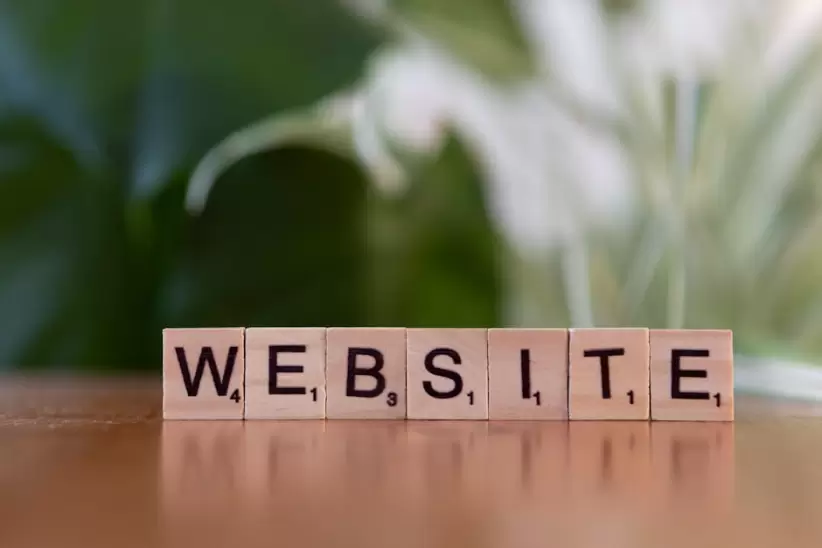 Fichas de Scrabble sobre una superficie de madera que forman la palabra 'Sitio web', que simboliza la comunicacin digital.