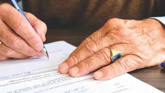 Persona Que Firma El Papel Del Documento. (Foto: Pexels)