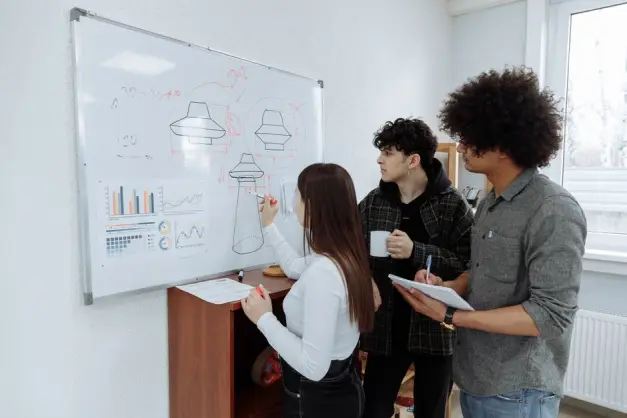 Jóvenes profesionales realizando una lluvia de ideas y diseñando un prototipo de producto en una pizarra. (Foto: Pexels)