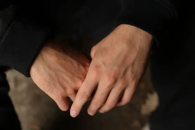 Una toma de primer plano de las manos de un hombre con un tono oscuro y melancólico, con iluminación natural. (Foto: Pexels)
