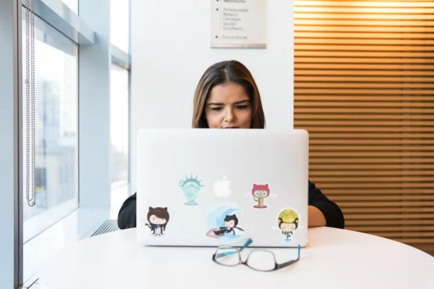 Mujer en foco trabajando en desarrollo de software de manera remota en un portátil en interiores. (Foto: Pexels)