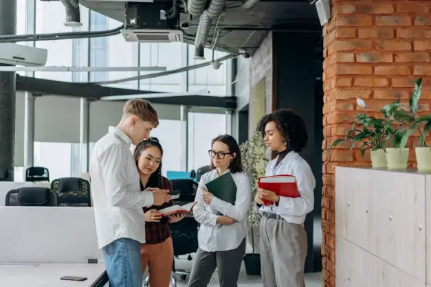 Un equipo diverso de profesionales colabora en un entorno de oficina moderna, intercambiando ideas. (Foto: Pexels)