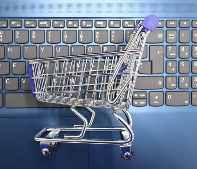 Un carrito de compras en miniatura colocado sobre un teclado portátil que simboliza las compras en línea y el comercio electrónico. (Foto: Pexels)