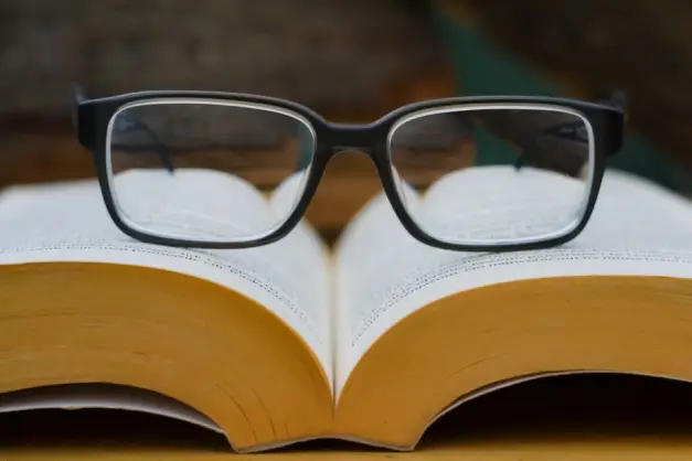 Gafas reposando sobre un libro abierto, destacando el tema de la lectura y la educación. (Foto: Pexels)