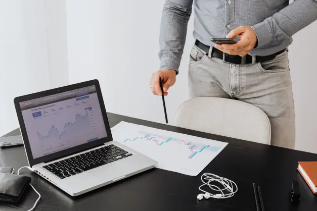 Profesional de negocios analizando tendencias de criptomonedas en un portátil con gráficos y tablas. (Foto: Pexels)