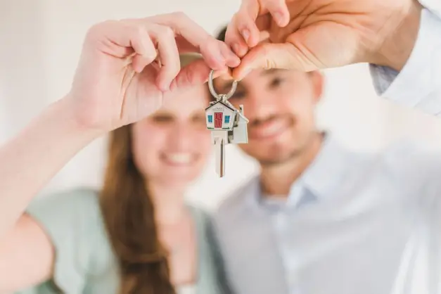 Joven pareja sosteniendo las llaves de su nuevo hogar, simbolizando un nuevo comienzo y una inversión en bienes raíces. (Foto: Pexels)