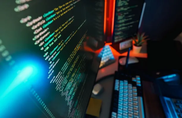 Espacio de trabajo futurista con una pantalla de computadora brillante con codificación mostrada, ideal para conceptos de tecnología y programación.