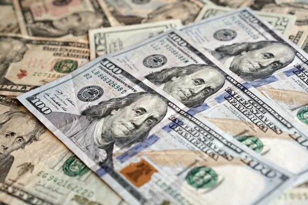 Vista de primer plano de la moneda estadounidense resaltando los billetes de cien dólares, que representan las finanzas y la economía.