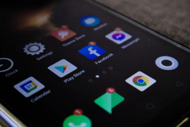 Vista detallada de la pantalla de un teléfono inteligente con íconos de aplicaciones populares, incluyendo Facebook y Messenger.