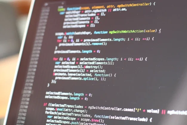 Vista en primer plano de código colorido en la pantalla de un portátil, mostrando conceptos de programación.