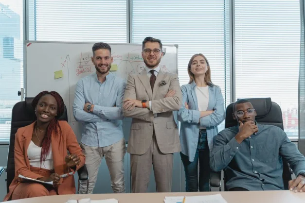 Un grupo multicultural de profesionales de negocios posando con confianza en una oficina moderna.