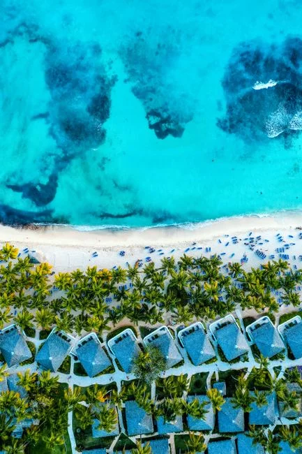 Impresionante toma aérea de la vibrante costa de Bayahíbe, mostrando aguas turquesas y villas frente a la playa.