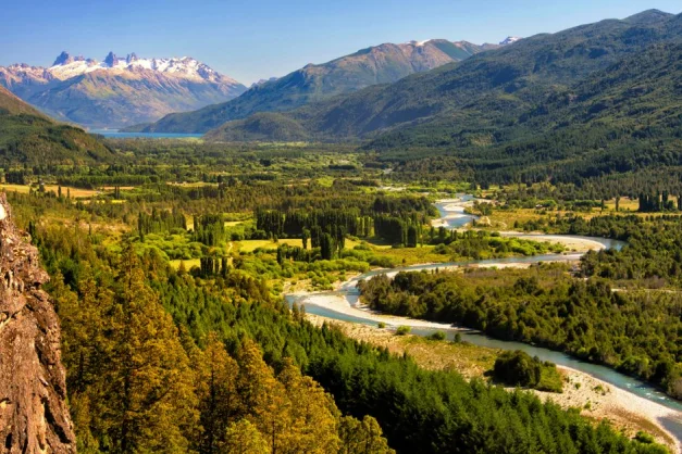 Impresionante vista de El Bolsón que muestra valles exuberantes, un río serpenteante y las montañas de los Andes.