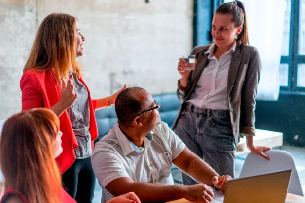 Un grupo diverso de profesionales discutiendo y colaborando en un entorno de oficina moderno.