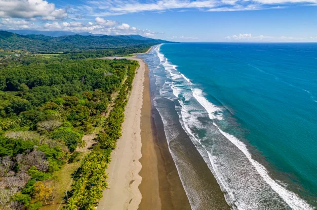 Una impresionante vista aérea de la costa en Puntarenas, Costa Rica, mostrando playas prístinas y exuberante vegetación.
