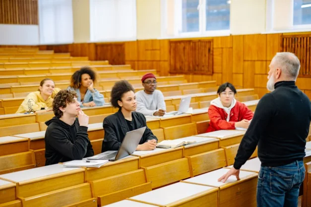 Estudiantes universitarios participando en un entorno de aula diverso con un conferenciante.