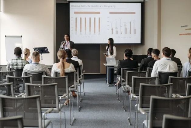 Seminario profesional de negocios con audiencia escuchando a presentadores compartiendo ideas sobre datos.