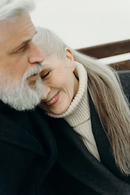 Cálido abrazo de una pareja mayor con cabello gris, mostrando amor y unión.