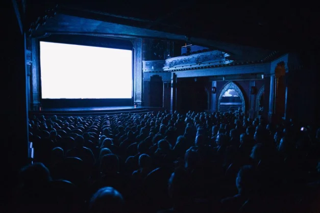Un cine lleno en Budapest con una audiencia viendo una película por la noche.