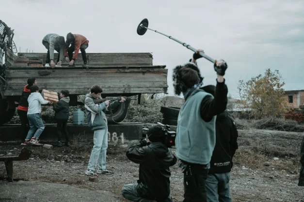 Equipo de filmación trabajando al aire libre, capturando escenas con cámara y micrófono boom.